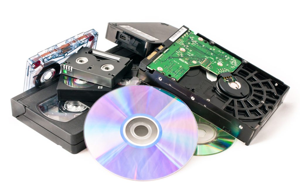 A pile of media waiting to be shredded by papermountains. Hard Drive, audio tapes, cd's, dvd's and data tapes.
