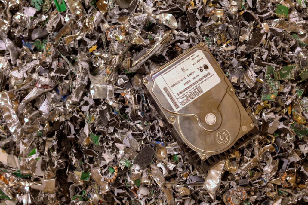 Hard Drive sitting on top of a pile of shredded hard drive materials